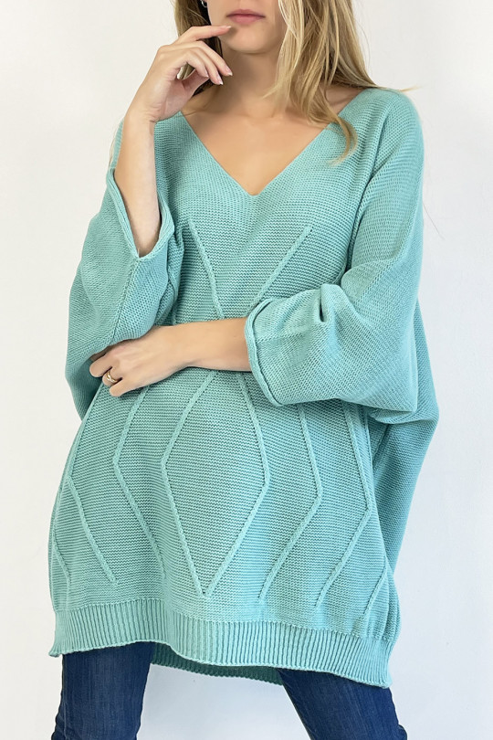 Long turquoise sweater with loose V-neck, knit effect with raised knit line detail that restructures the silhouette - 1