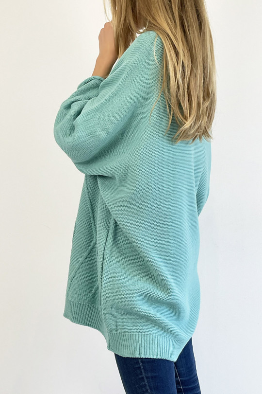 Long turquoise sweater with loose V-neck, knit effect with raised knit line detail that restructures the silhouette - 4
