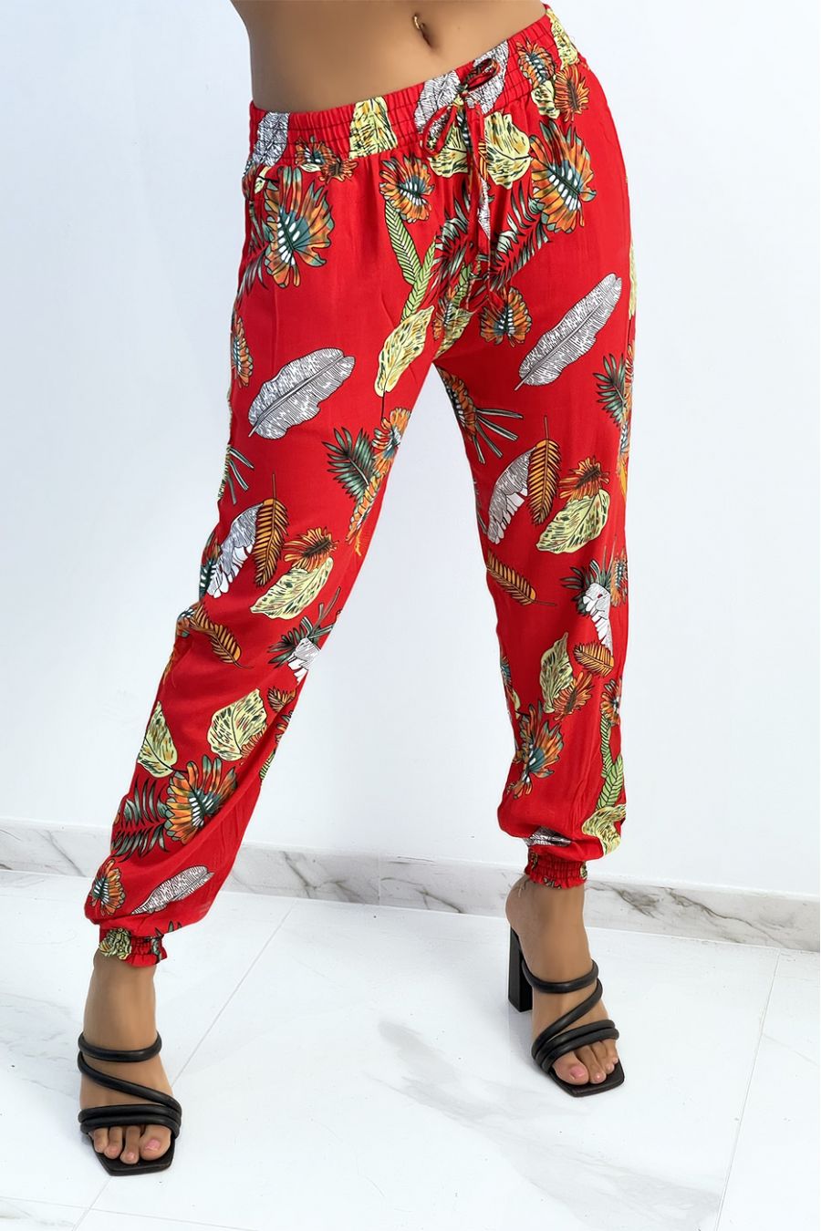 Pantalon fluide rouge à motif feuillage