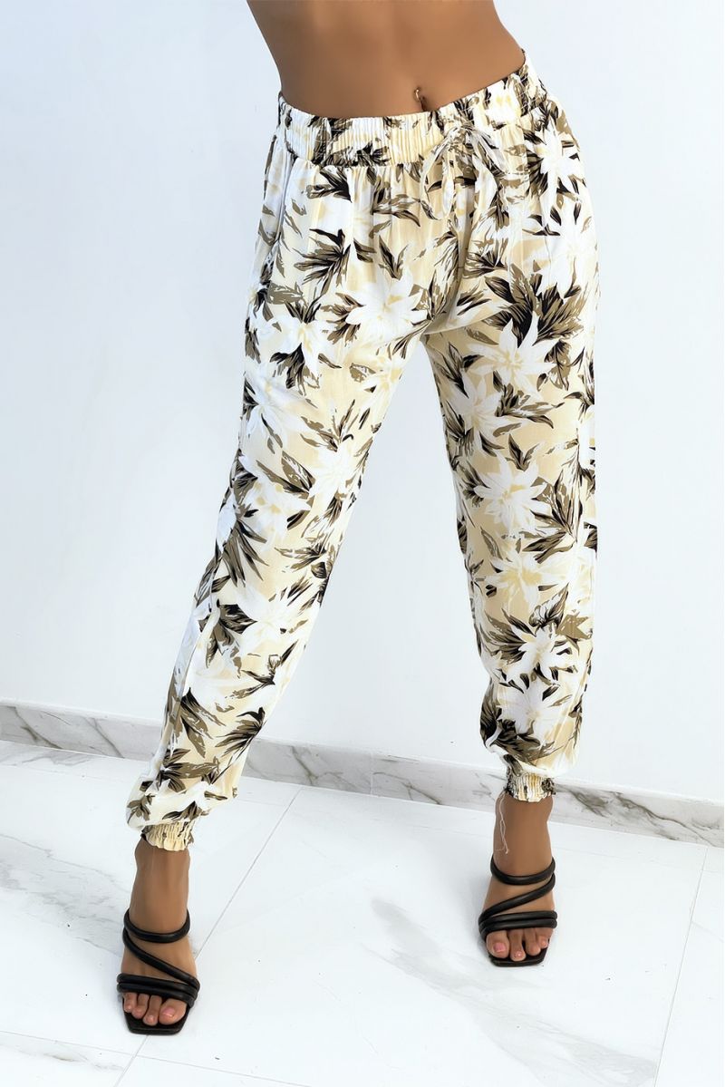 Flowing beige pants with tropical print tightened at the ankles - 1
