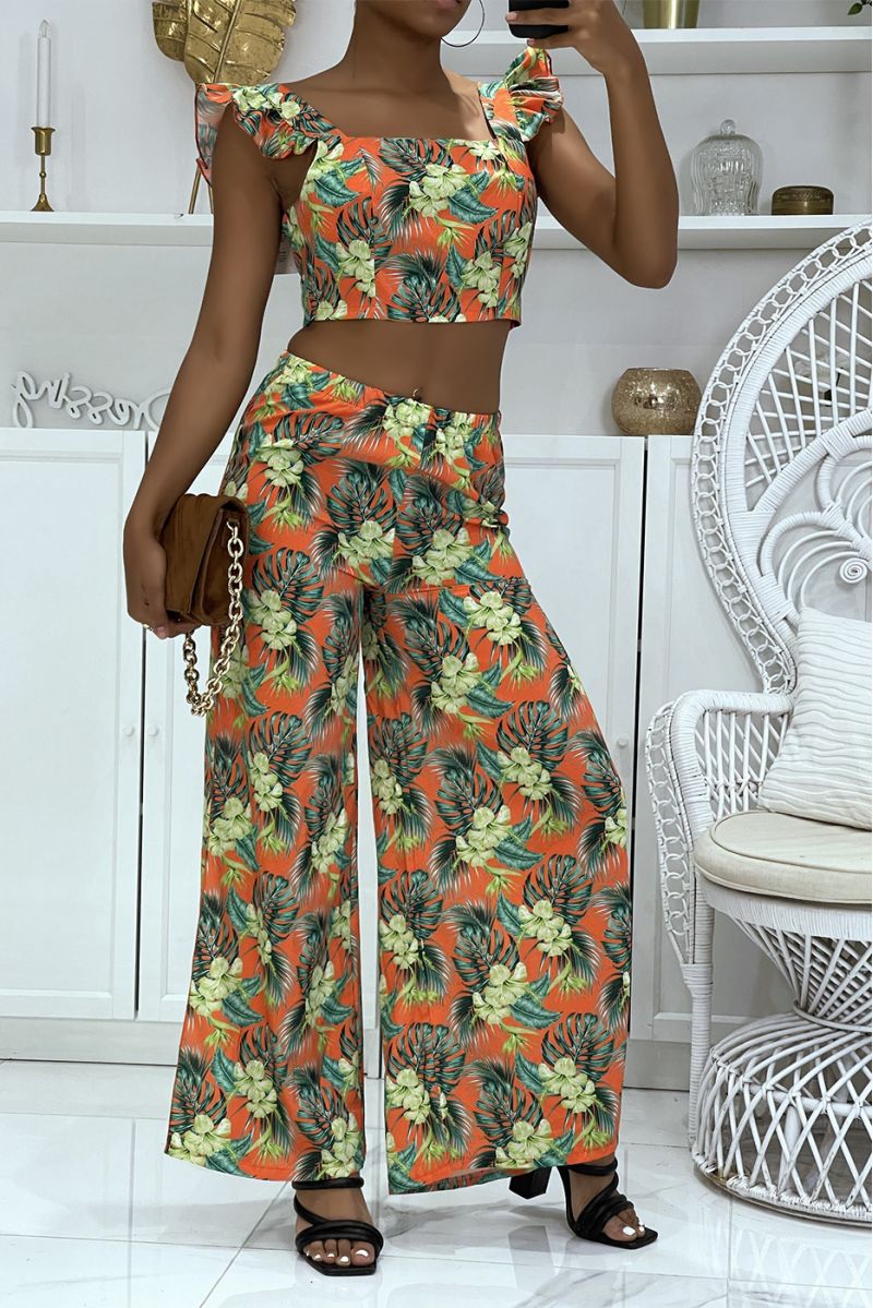 Prachtige bloemenoranje set met olifantenbeenbroek met splitten aan de zijkanten en crop top die aan de achterkant gestrikt word