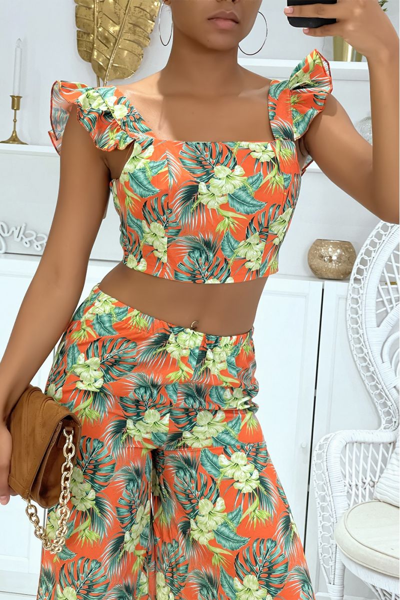 Prachtige bloemenoranje set met olifantenbeenbroek met splitten aan de zijkanten en crop top die aan de achterkant gestrikt word